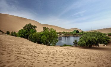 Die Oase und Lagune Huacachina inmitten von Sanddünen bei Ica