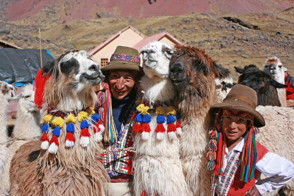Einheimische posieren mit ihren Lamas vor der Chillca Lodge