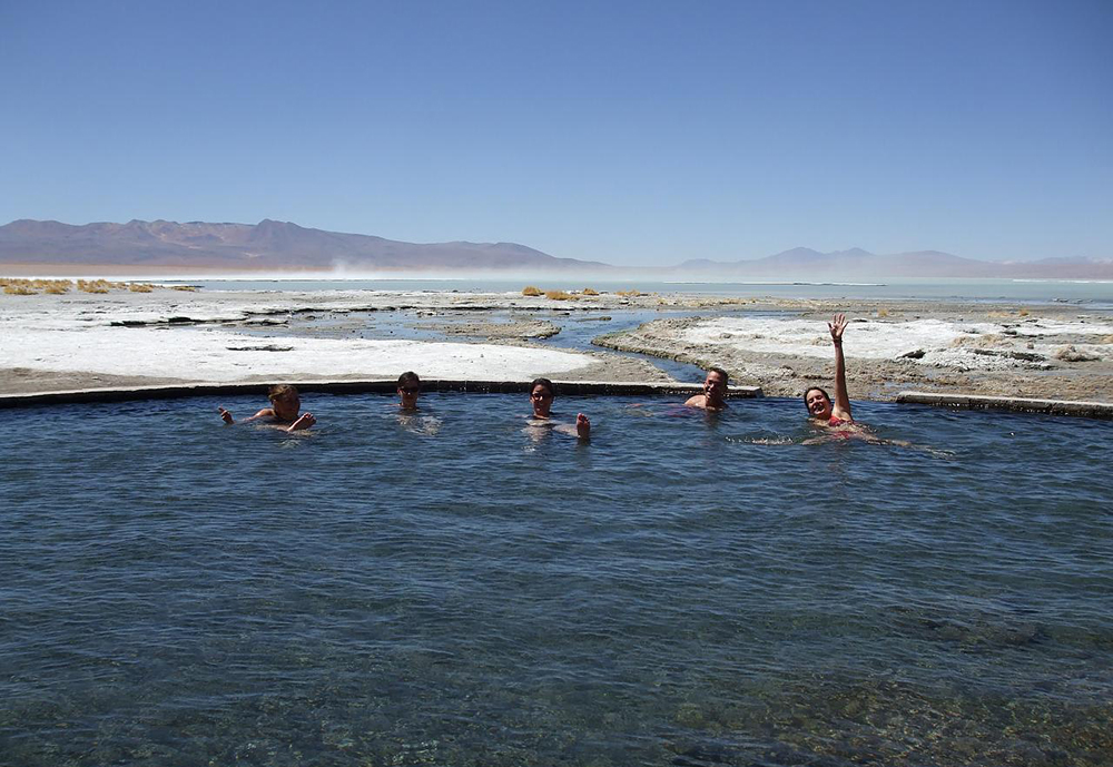 Touristen baden im Thermalbad Polques in der Salar de Uyuni
