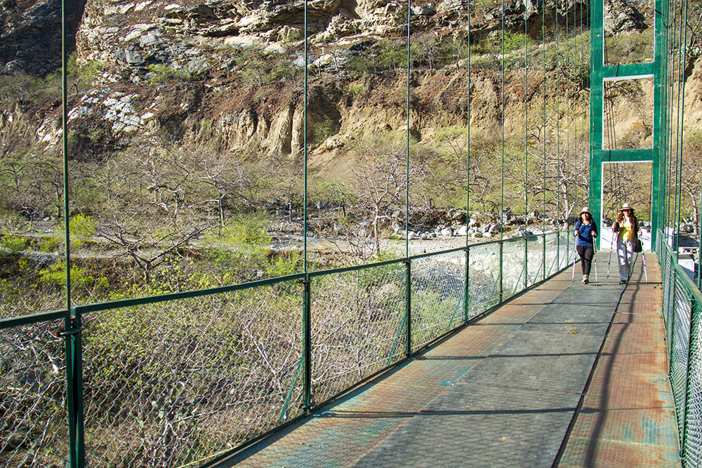 Zwei Frauen wandern über die Hängebrücke im Apurimac Canyon auf dem Choquequirao Trek