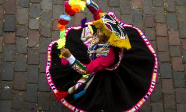 Eine Frau in traditioneller Kleidung bei einem typischen Tanz in Cusco
