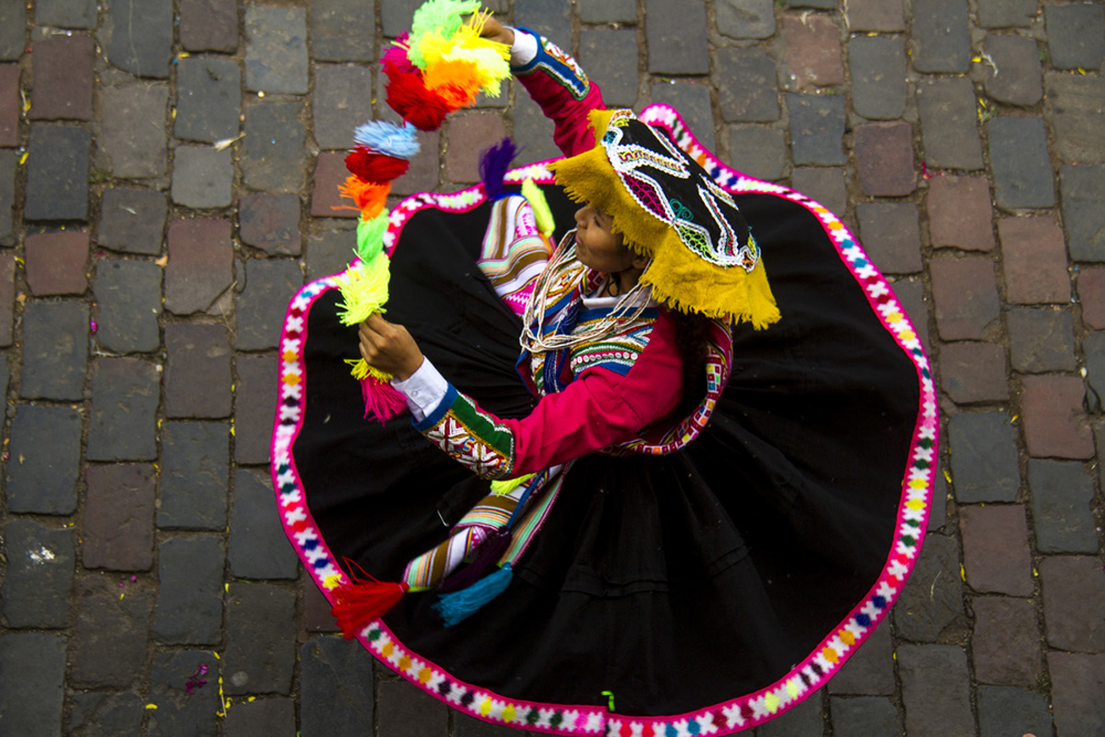 Eine Frau in traditioneller Kleidung bei einem typischen Tanz in Cusco