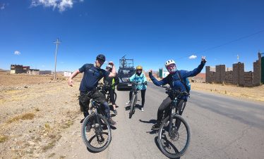 Radfahrer posieren vor dem Begleitfahrzeug