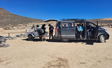Die Gruppe macht eine Rast beim Begleitfahrzeug der Tour