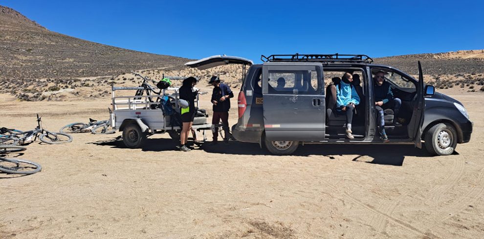 Die Gruppe macht eine Rast beim Begleitfahrzeug der Tour