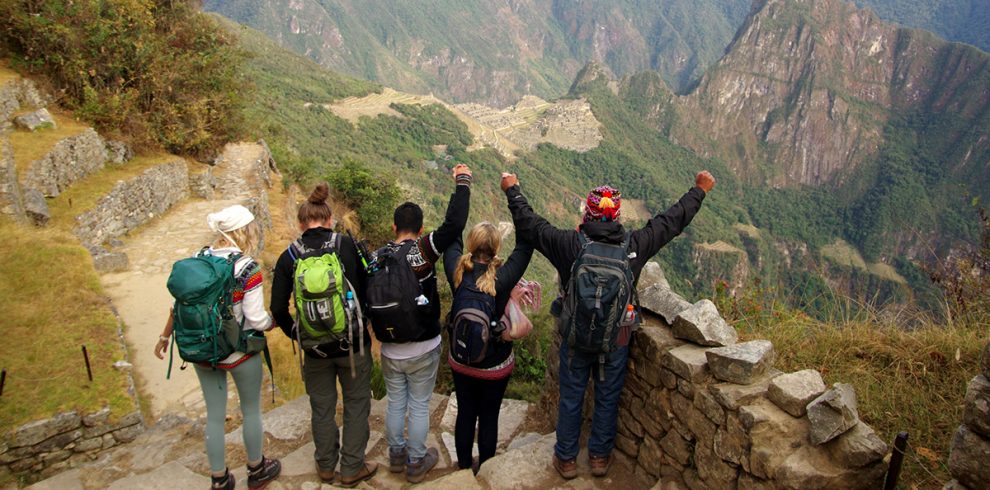 Ein Gruppe blickt vom Inti Punku, dem Sonnentor, am Ende des Inka Trails auf Machu Picchu