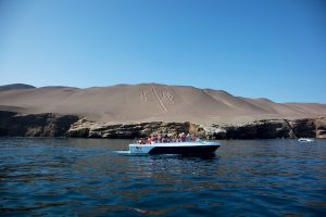 Touristen fahren mit dem Boot am Kandelaber im Naturschutzgebiet Paracas vorbei