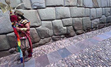 Ein "Inka" vor dem Stein "12 angulos" im historischen Zentrum in Cusco