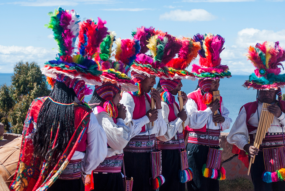 Traditionell gekleidete Männer spielen auf der Insel Taquile im Titicacasee Panflöte