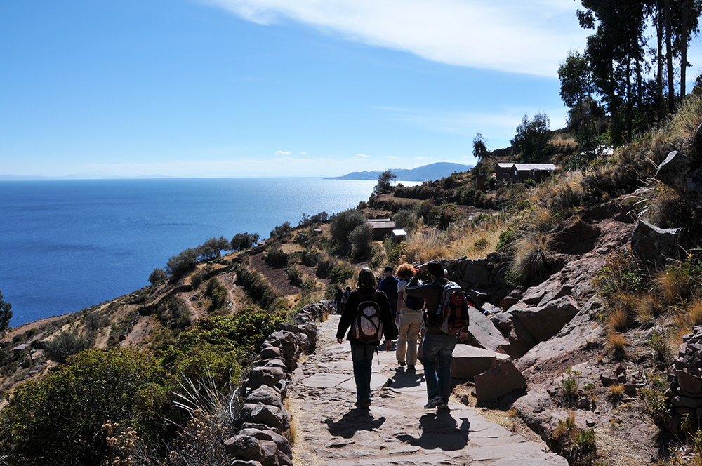 Touristen laufen den Weg hinunter auf der Insel Taquile im Titicacasee
