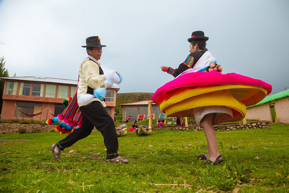 Ein Paar tanzt einen traditionellen Tanz in der Luquina Chico Lodge am Titicacasee