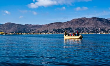 Eine Schilfboot steuert die Schilfinseln der Uros im Titicacasee an