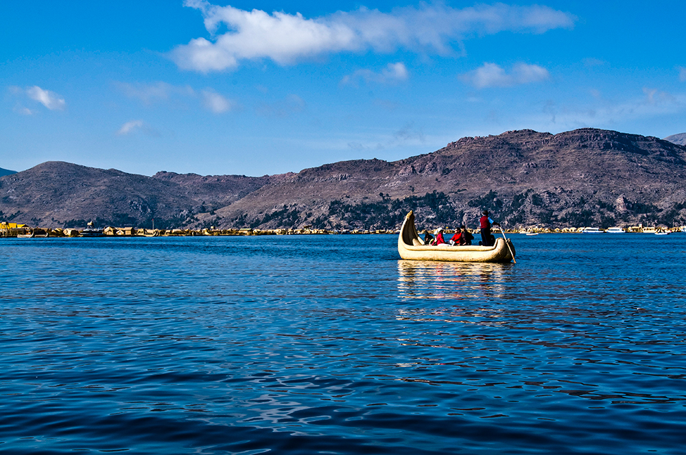 Eine Schilfboot steuert die Schilfinseln der Uros im Titicacasee an