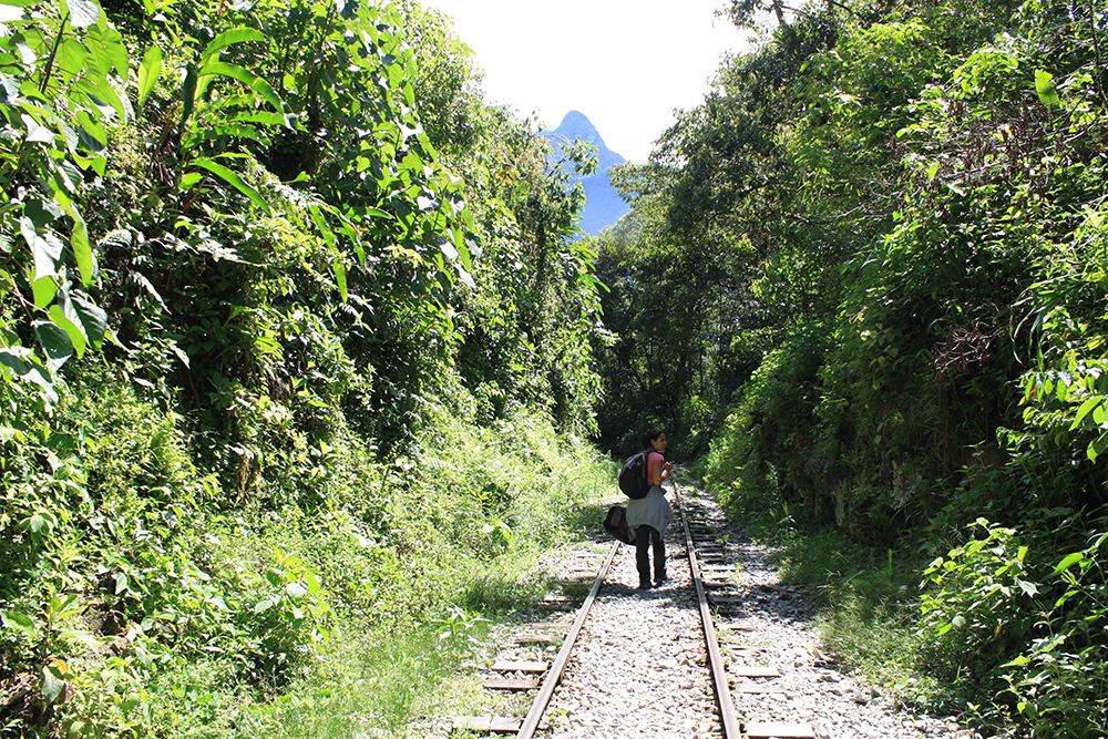 Eine Touristin wandert von der Bahnstation Hidroelectrica an den Gleisen entlang in Richtung Aguas Calientes